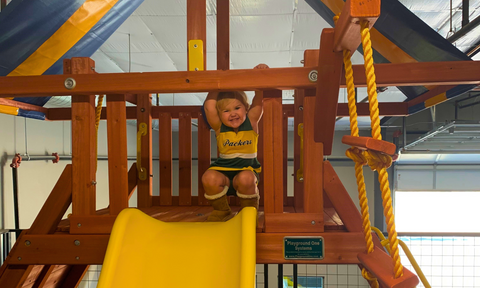 Child enjoying a Playground One swing set at the River City Play Systems Tradesman showroom