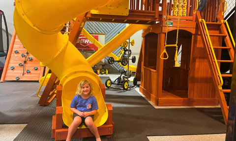 Girl going down spiral slide at the Schertz store